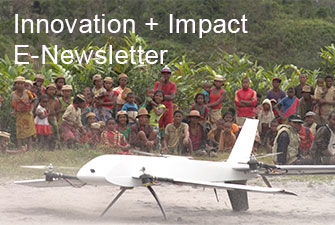 Photo of villagers gathered around a UAV on the ground. Innovation + Impact E-Newsletter