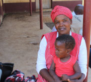 Setsabile and her baby, Njabulo, wait to receive food assistance through USAID partner World Vision. Photo World Vision
