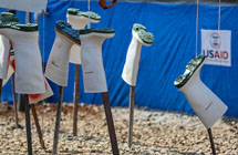 After being treated with chlorine, rubber boots dry in the sun, where the chemical and UV rays ensure that all possible traces of the Ebola virus are killed before another wear. Photo by Adam Parr, USAID