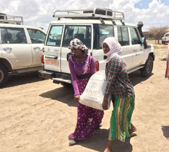 Beneficiaries leave a relief food distribution site with their food rations. Because of the drought, many families in Ethiopia are dependent on this assistance to put food on the table. / Sarah Berry, USAID 