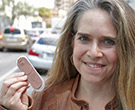 Woman holds object resembling a band-aid.