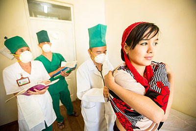 A woman is examined by a doctor for TB