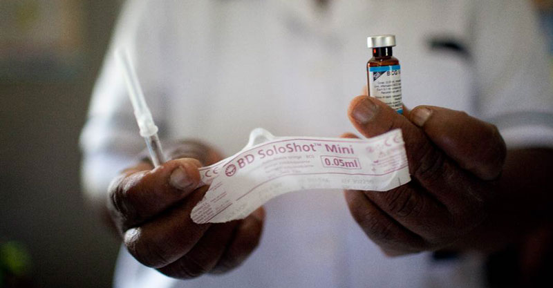 An image of a health care working holding a BD SoloShot Mini vaccine. Credit: PATH
