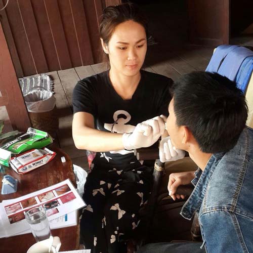 A community-based supporter administers the OraQuick test to a client, who hesitated to get tested for HIV due to his fear of needles and concern that people would learn of his sexual orientation. 