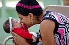 A mother kisses her baby who was born without HIV