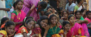 Photo of young girls in India watching a play about adult being encouraged to get tested for HIV.
