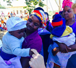 At a health clinic, Dina Esposito speaks with mothers benefiting from the Amalima program. / Jason Taylor, USAID 