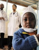 A child peers around the corner in the waiting room of the HIV Comprehensive Care Clinic of Meru District Hospital in Kenya
