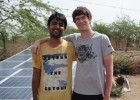Yashraj Khaitan (left) and Jacob Dickinson, both founders of Gram Power, stand next to several solar panels in India. The panels