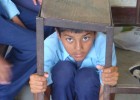 A student from Shree Janaudaya Lower Secondary School in Kathmandu, Nepal, demonstrates how to take cover during an earthquake. 