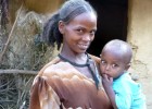 A mother holds her child at their “model home” in a village outside Enticho Tigray, Ethiopia, served by the Endamariam Health Po