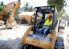Roselette Dupervil, a heavy machinery operator, talks to a colleague from her seat inside an excavator Feb. 14 as she clears rub