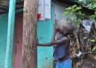 A Haitian boy inspects the installation of an early-stage microgrid meter box.