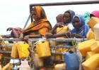 Ethiopian women grab containers with filled with fresh water