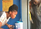 Sylvia Awuni helps a client make a mobile money transaction.