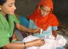 A community health volunteer applies chlorhexidine to the umbilical cord of a newborn delivered at home in Banke district.