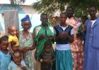 Rougui Diallo’s family poses for a photo with two community health workers, at right, after a home visit.