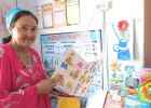 A school librarian shows off books at a library in Tajikistan established by USAID.