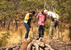 A BioCarbon Partners Trust staff member, right, explains the charcoal production process and improved kiln technology.