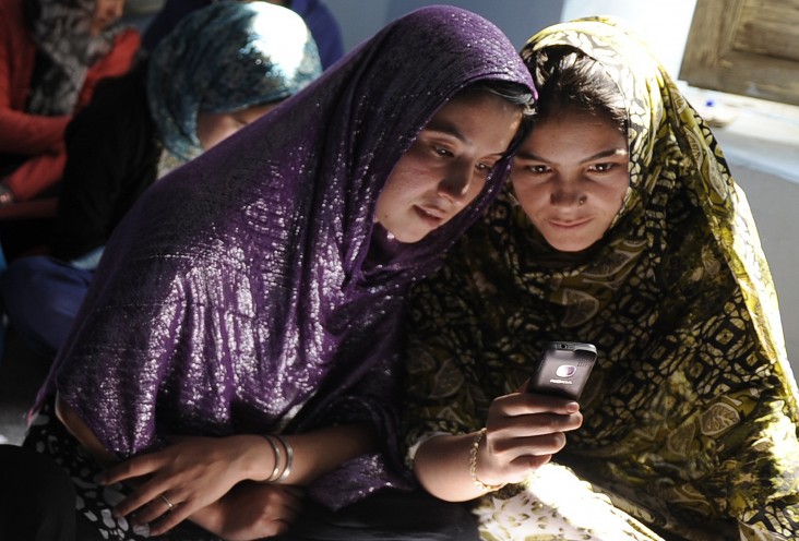 Afghan women sit in a class and study using mobile phones in Kabul
