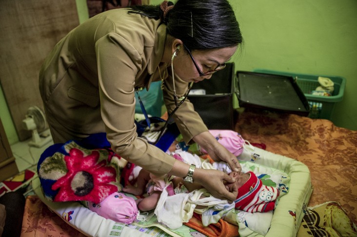 Bidan Tatik, dari Desa Donomulyo, Jawa Timur, Indonesia sedang melakukan panggilan rumah untuk mengunjungi seorang ibu dan bayin