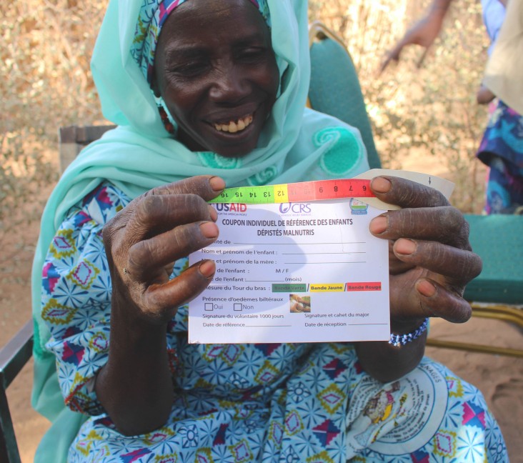 A woman shows off a baby weighing card in Niger
