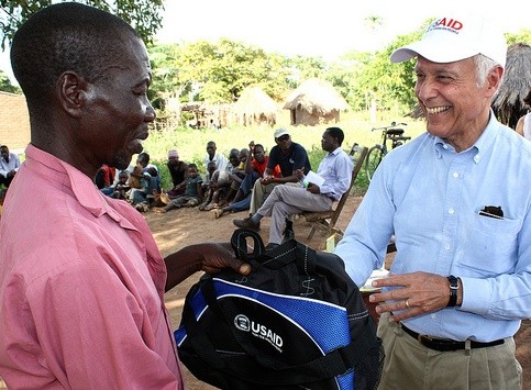 USAID/Zambia Mission Director Dr. Michael Yates offers a customary token of appreciation to a village headman in Zambia's Easter