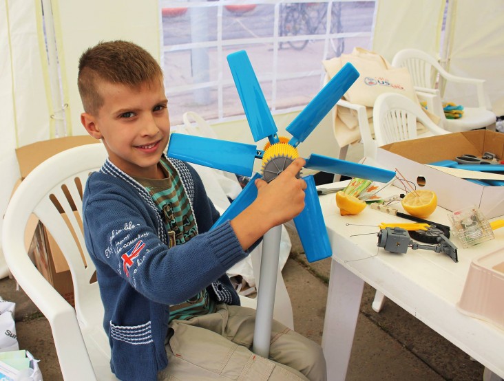 A young enthusiast displays a model of wind turbine he assembled at an Energy Efficiency Lab during a USAID City Day in Sumy.