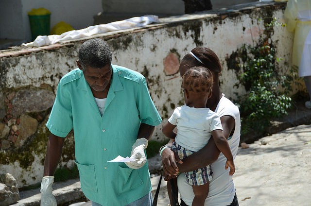 Doctor with mom and baby at St. Justinien Hospital in Cap Haitien, Haiti, where USAID is constructing a new maternity ward.