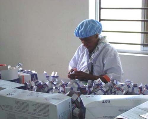 A Social Marketing Company employee packs injectables at a warehouse.