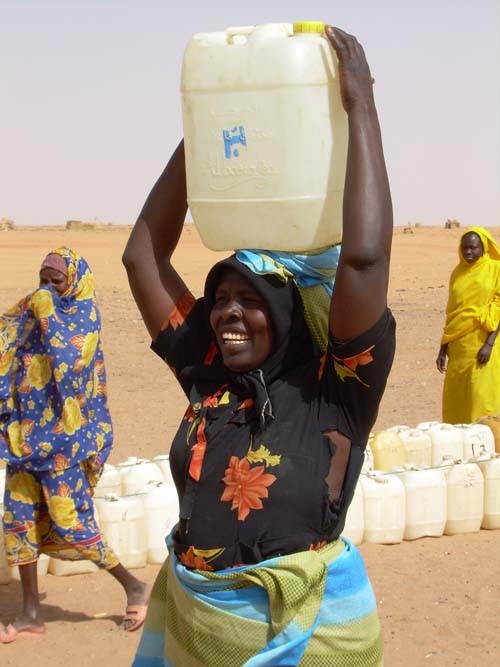 A woman carries water in Abu Shook camp for internally displaced persons near El Fasher. 