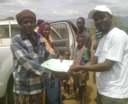 An Ethiopian pastoralist receives a copy of his new insurance policy.