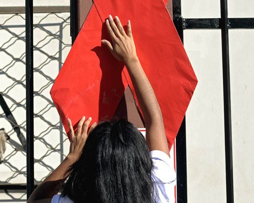 An activist sets up a red ribbon during the commemoration of the World AIDS Day in San Salvador, on December 1, 2010.