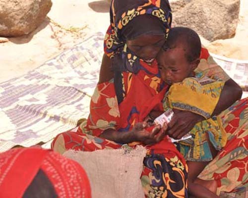 An Ethiopian woman feeds Plumpy’nut peanut paste to her 1-year-old daughter at a therapeutic feeding center.