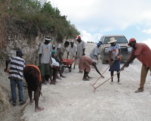 Members of the Fond Baptiste community carry out labor-intensive road maintenance.  
