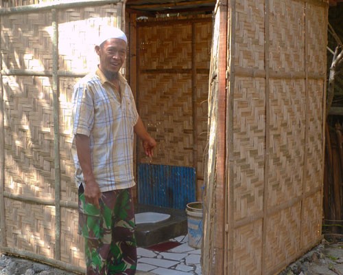 Syamsudin Sitaba of Empoang Utara in Jeneponto district shows his newly installed toilet following an IUWASH–assisted Ministry o