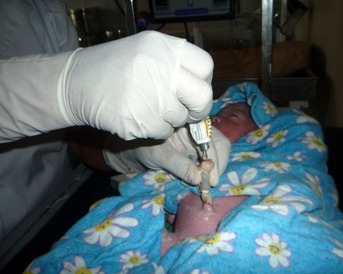 A health worker applies chlorhexidine to the cord of a newborn baby born in the Banke district health facility