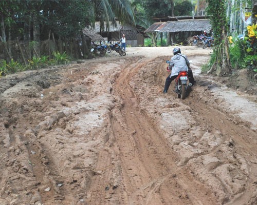 Residents of Olutanga Island like Lolita Singahan travel over unpaved roads spewing dust in summer and turning muddy during the 