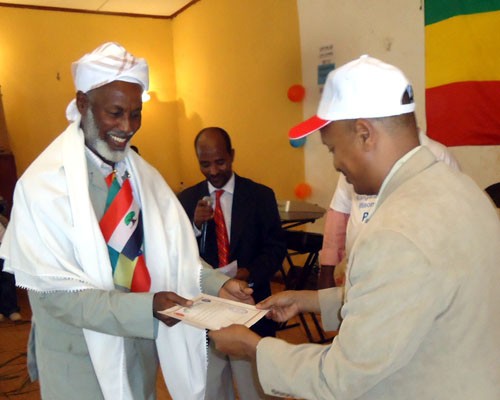 Sultan Mohammed Hassen Gababa, traditional leader of the Gari clan, receives a certificate from Shiferaw Tekle-Mariam, minister 