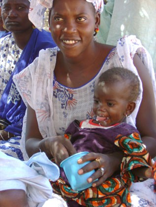 A Sengalese mother feeds her baby daughter fortified cereal for better nutrition.