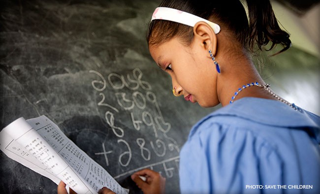 Image of young girl writing on chalkboard in Bangladesh