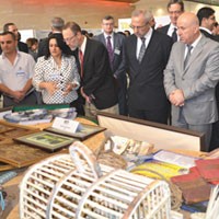 Erbil Gov. Nawzad Hadi (in gray suit) and USAID representatives from Baghdad inspect handicrafts produced by microloan beneficia