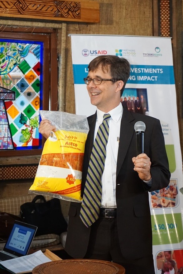 U.S. Deputy Chief of Mission Peter Vrooman holds a bag of fortified wheat flour