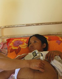 A health center midwife performs a check-up on an expectant mother.