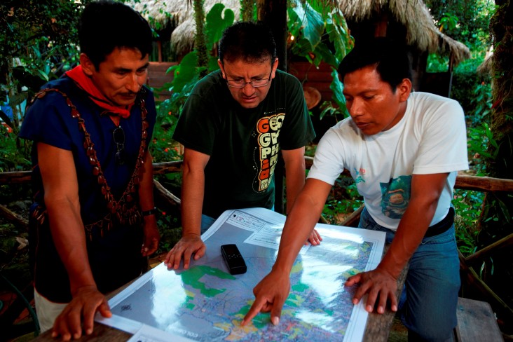 William Lucitante, right, confers with Marcelo Guevara of The Nature Conservancy, center, and a Cofan ranger.