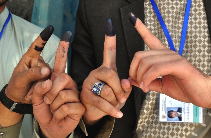 Voters display their inked fingers after casting votes at a polling station in Kabul.