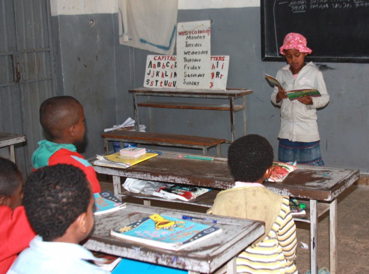 Birhane Primary School summer reading camp student Selam Tamene reads a "Tsehai Loves Learning" storybook to her classmates.