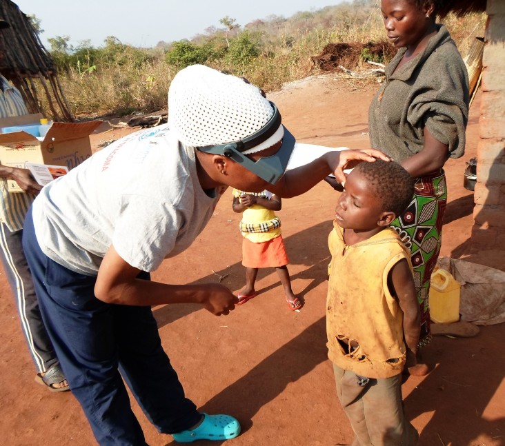 A field officer examines a child for trachoma.