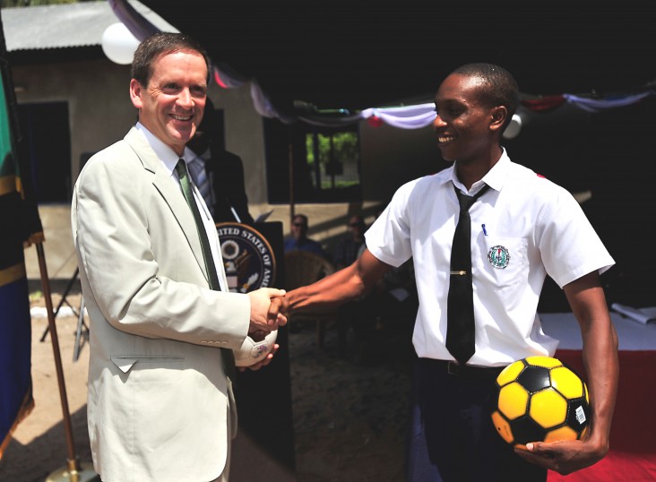 Ambassador Mark Green presents a student with a soccer ball during a dedication ceremony at Jitegemee Secondary School in Dar es Salam, Tanzania. 