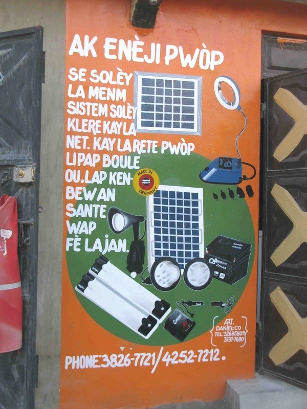 An Enèji Pwòp reseller painted an illustrative ad on her store to promote the solar products she sells.